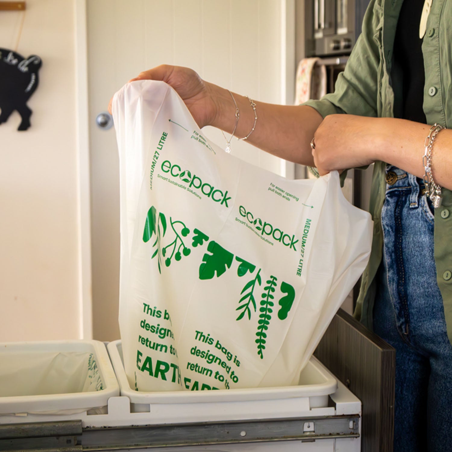 Ecopack 27L compostable bin liner being pulled up from a kitchen bin