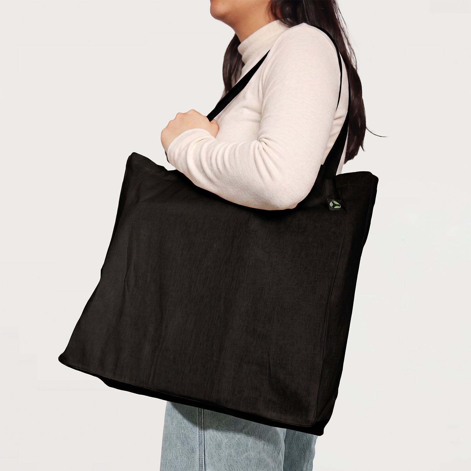 Model carrying black calico tote bag with bottom gusset and long handles