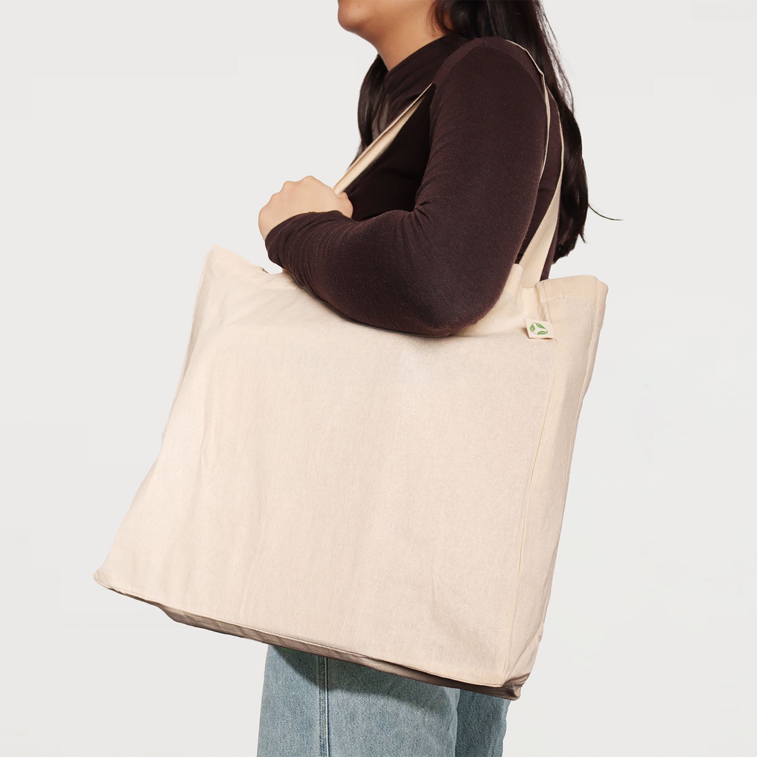 Model carrying natural calico tote bag with bottom gusset and long handles