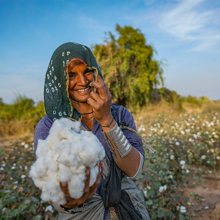 Woman holding raw cotton in field