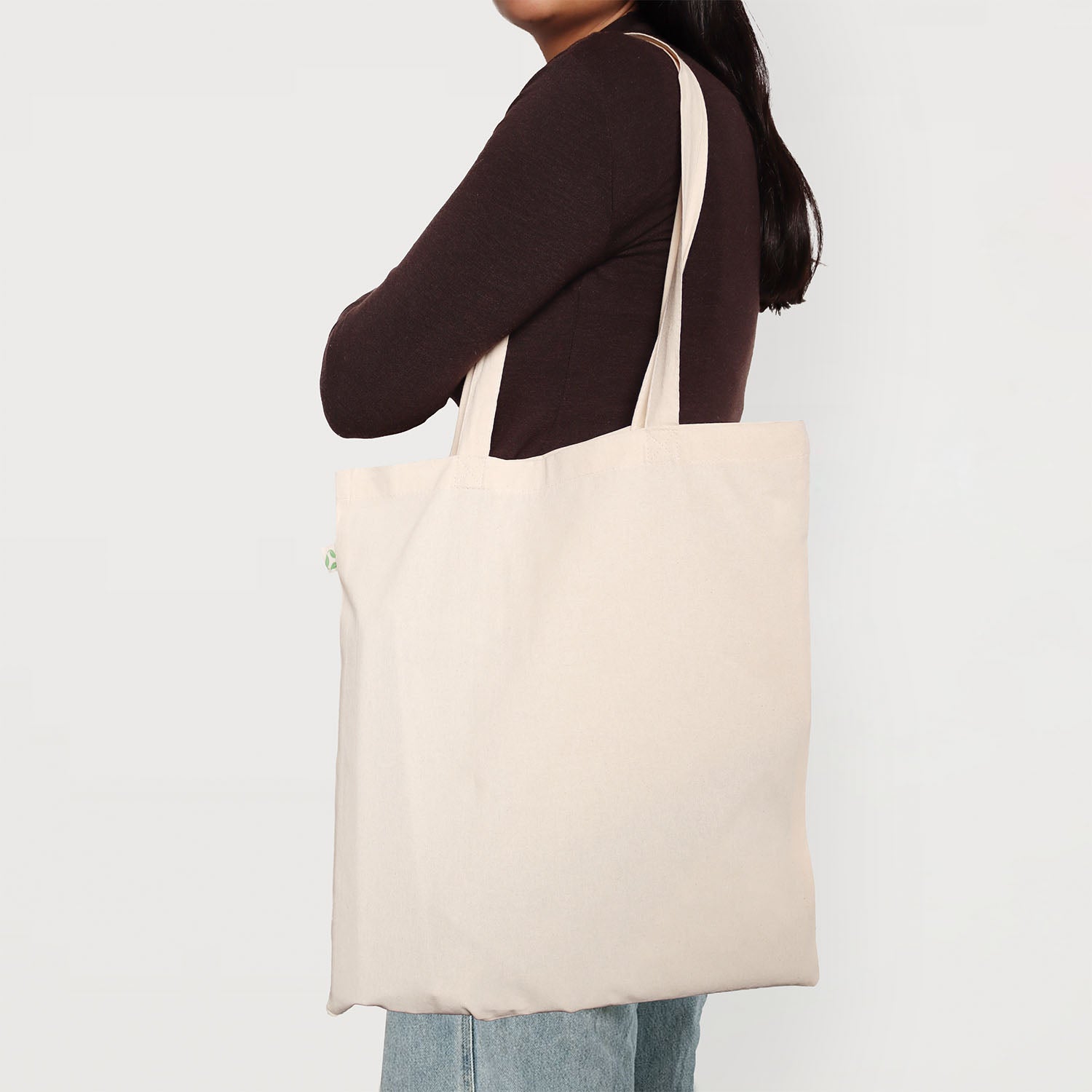 Model carrying a natural calico promotional tote bag